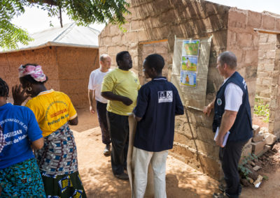 Un membre de l'association Pompiers Solidaires établi un plan d'intervention en cas d'incident dans le village de Notse avec des habitants du village