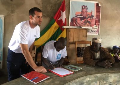 Un membre de Pompiers Solidaires signe une cinvention de partenariat avec un chef de village