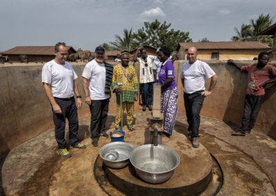 Trois bénévoles de Pompiers Solidaires et deux membres d'un village du Togo autour d'un puits finalisé