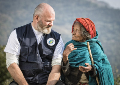 Philippe Etchebest, parrain de Pompiers solidaires, à côté d'une vieille femme népalaise